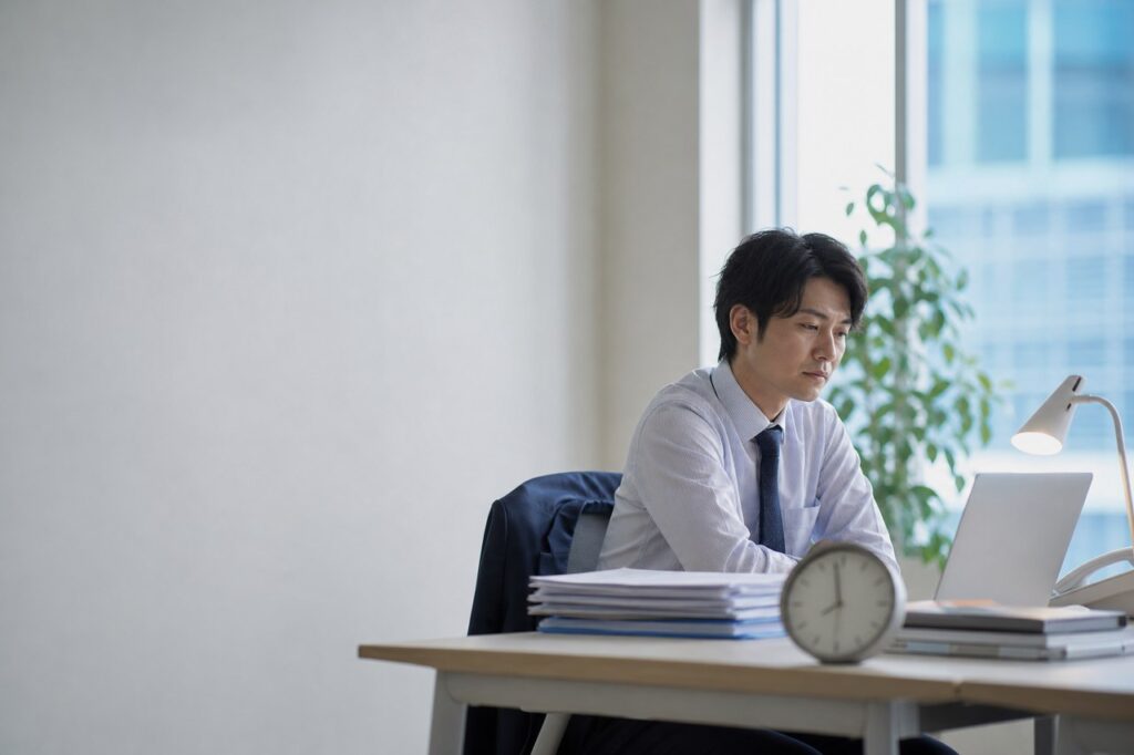 窓辺のオフィスで残業する会社員